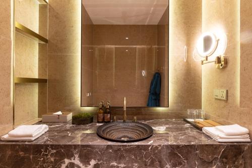 a bathroom with a sink and a large mirror at SOMA HOTEL Riverside in Phnom Penh