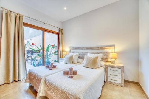 a bedroom with two beds and a large window at Ideal Property Mallorca - Villa Placeta in Sa Pobla
