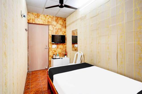 a bedroom with a white bed and a tv at Collection O Vadapalani Metro Station Vishnu's Galaxy Rooms in Chennai