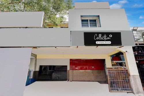 a white building with a sign for a store at Collection O Vadapalani Metro Station Vishnu's Galaxy Rooms in Chennai