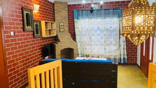 a room with a brick wall and a table and chairs at parachichi house Bed and Breakfast in Arusha
