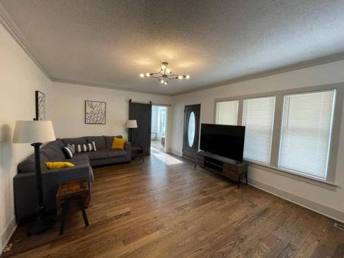 a living room with a couch and a flat screen tv at Charming Retreat 5 Min to Tims Ford Lake Sleeps 8 in Winchester