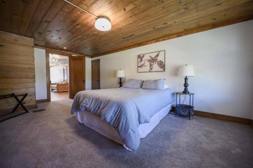 a bedroom with a large bed and a wooden ceiling at Charming Retreat 5 Min to Tims Ford Lake Sleeps 8 in Winchester