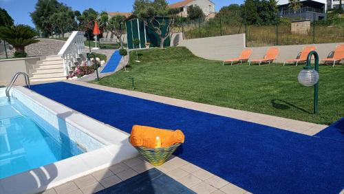 a swimming pool with a blue carpet next to a yard at Comfort &Relax B&B&Spa in Villa Rosa