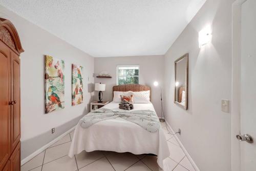 a bedroom with a bed with a cat sitting on it at Beach Apart By Pmi Unit 3 in West Palm Beach