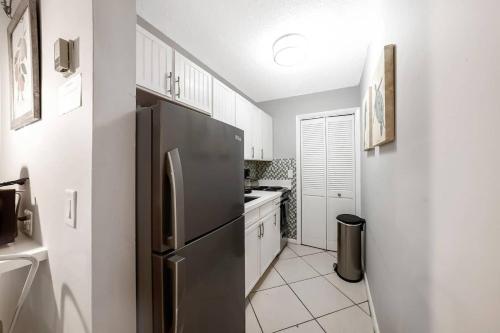 a kitchen with a stainless steel refrigerator and white cabinets at Beach Apart By Pmi Unit 3 in West Palm Beach