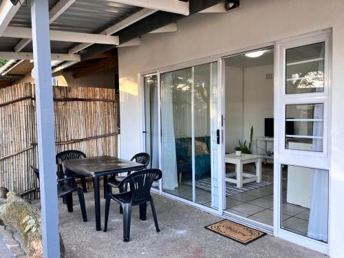 a screened in porch with a table and chairs at Stay Inn in Gonubie