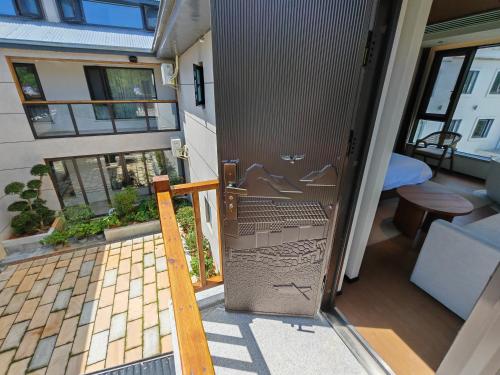 an open door to a balcony in a tiny house at Lushan Youlu Villa in Jiujiang