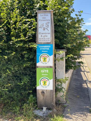 a sign that is next to a hedge at Le clos des Pommiers Fuji in Uffholtz