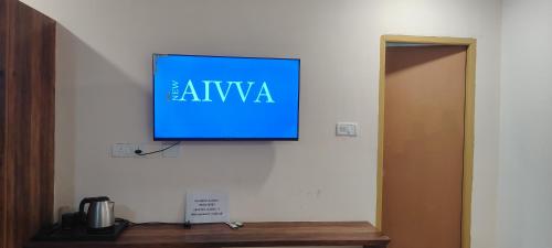 a flat screen tv hanging on a wall at Navya Grand Medchal in Hyderabad