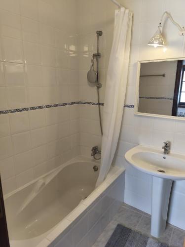 a white bathroom with a tub and a sink at Casa do Canto Obidos in Amoreira