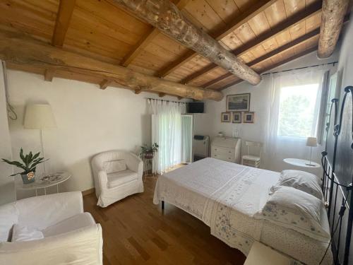 a bedroom with a bed and a chair at B&B Il Giardino in Melara