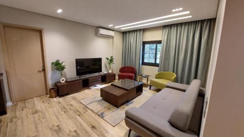 a living room with a couch and a tv at Maison 7 New Cairo in Cairo