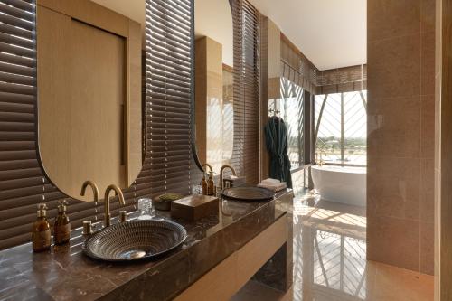 a bathroom with a sink and a large mirror at SOMA HOTEL Riverside in Phnom Penh
