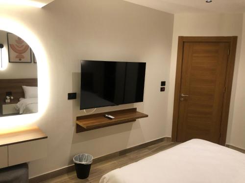 a bedroom with a flat screen tv on the wall at House 98 - Boutique Hotel Stay in Zayed in Sheikh Zayed