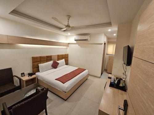 a bedroom with a bed and a television in it at Hotel Horizon Plaza in Gwalior
