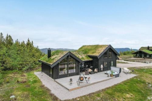 an image of a black house with a grass roof at Cabin with jacuzzi on Lifjell in Lifjell