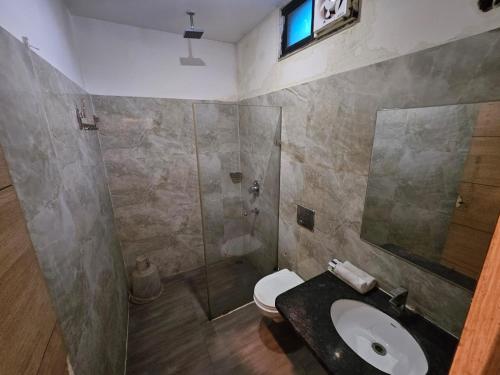 a bathroom with a toilet and a sink and a shower at Hotel Horizon Plaza in Gwalior