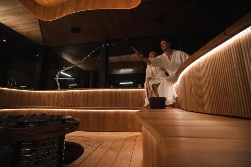 a man in a robe standing on a dance floor at Aurora Hut Igloo by Invisible Forest Lodge & Spa in Rovaniemi