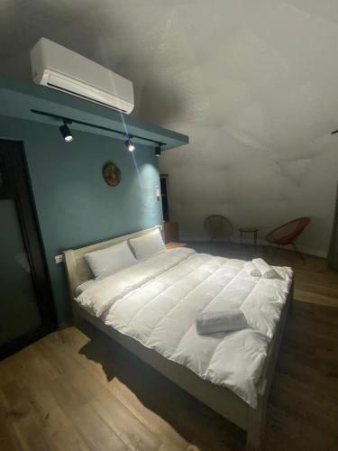 a bedroom with a large white bed with a fan at SaguleResort in Monasteri
