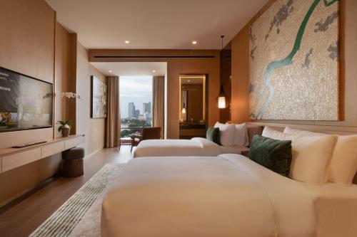 a hotel room with two beds and a television at SOMA HOTEL Riverside in Phnom Penh