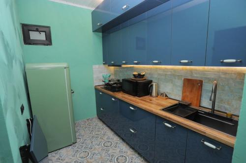 a kitchen with blue cabinets and a sink at SaguleResort in Monasteri