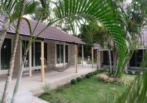 a house with a hammock in front of it at Bunyagard Koh Kood Resort in Ban Lak Uan