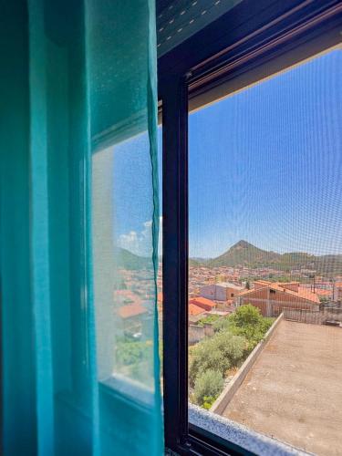 a window with a view of a city at Brebei Niedda Hostel in Gonnesa
