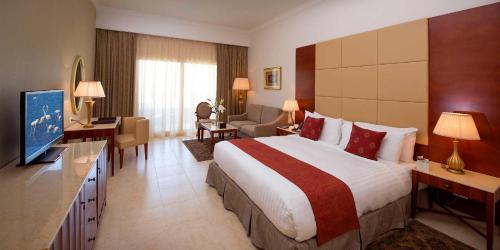 a hotel room with a large bed and a living room at Baron Palace Sahl Hasheesh in Hurghada