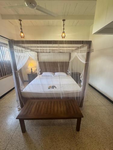 a bed with a canopy in a room at White on White in Hikkaduwa