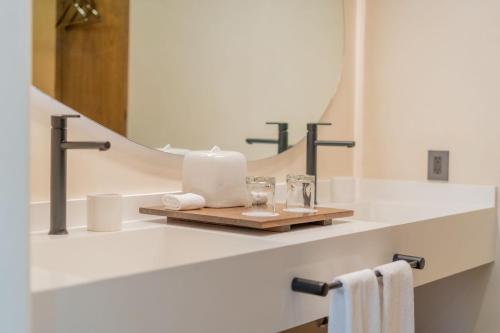 a bathroom with a shelf with towels and a mirror at Hotel Indigo La Paz Puerta Cortes by IHG in La Paz