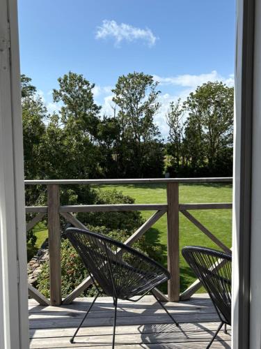two chairs on a porch looking out at a field at Hönshuset Kullabygden in Höganäs