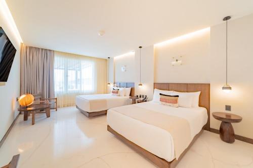 a hotel room with two beds and a television at Hotel Indigo La Paz Puerta Cortes by IHG in La Paz