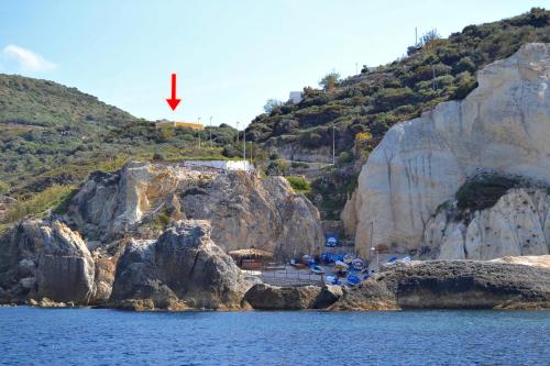 a group of people sitting on the rocks near the water at Maridea - Vairone in Ponza