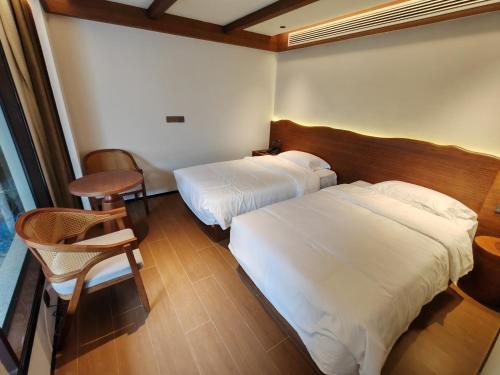 a hotel room with two beds and a chair at Lushan Youlu Villa in Jiujiang
