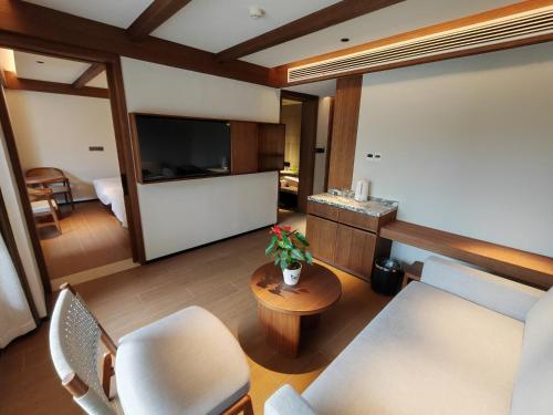 a living room with a couch and chairs and a television at Lushan Youlu Villa in Jiujiang