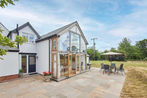an extension to a home with a conservatory and patio at Host & Stay - Merrow Cottage in Great Malvern