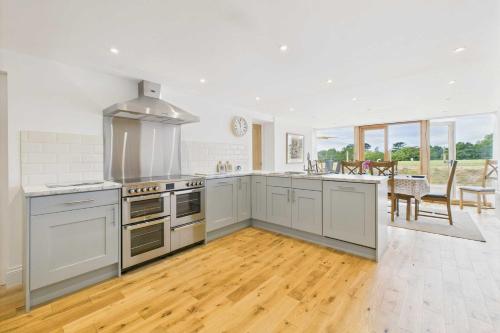 una cucina con elettrodomestici bianchi e una sala da pranzo di Host & Stay - Merrow Cottage a Great Malvern