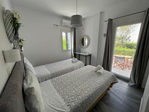 a bedroom with two beds and a window at Marioly Studios in Parikia