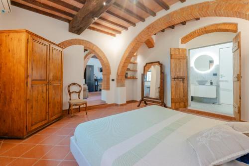 a bedroom with a bed and a chair at Tenuta Alela in Figline Valdarno