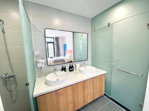 a bathroom with two sinks and a mirror at Lustay Triple Room- KD518- 3 giường in Ðình Loan