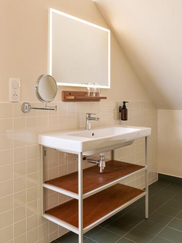 a bathroom with a sink and a mirror at Alfred Hotels Beaune La Madeleine in Beaune