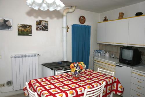 una cocina con una mesa con un jarrón de flores. en Don Pasquale Scontrone House, en Scontrone