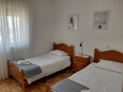 een slaapkamer met 2 bedden en een nachtkastje met een bed sidx sidx sidx sidx bij Correia Villa in Barcelos