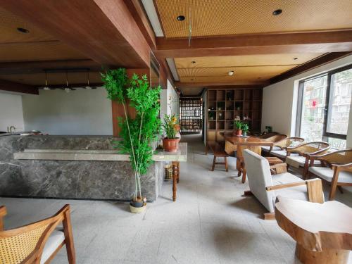 a restaurant with wooden ceilings and tables and chairs at Lushan Youlu Villa in Jiujiang