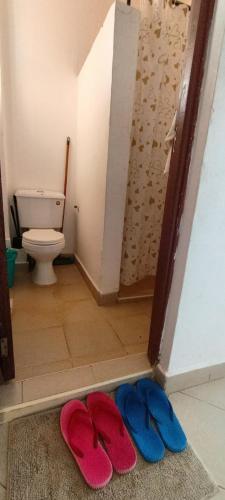 two flip flops on the floor of a bathroom with a toilet at Studio solace kitisuru in Nairobi