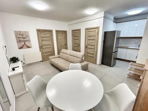 Una sala de estar con una mesa y sillas blancas. en Louise Suites, en Nyíregyháza