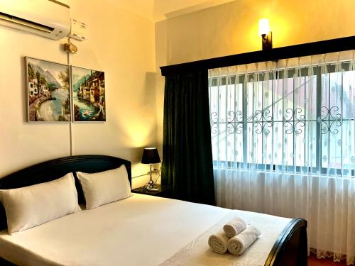 a bedroom with a bed with two towels on it at La Bella By The Beach Goa in Goa