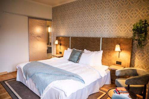 a hotel room with a large bed and a chair at Home Hotel Havnekontoret in Bergen