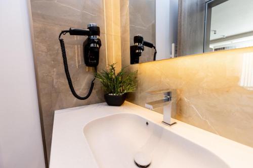 a bathroom with a sink and a phone on the wall at Villa Bijoux in Ploieşti